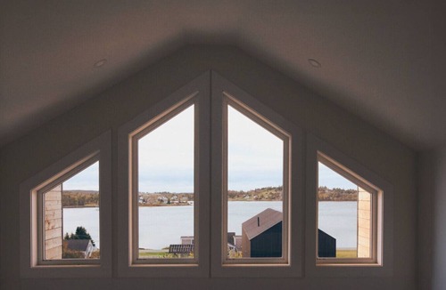 Riverport Cabin | A sanctuary of architectural restraint, unmediated coastal observation, and premium electric travel infrastructure.