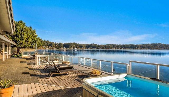 Waterfront home with private hot tub, game room with game tables, and water toys